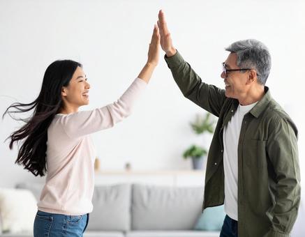 ハイタッチを交わすミドルエイジ夫婦の写真