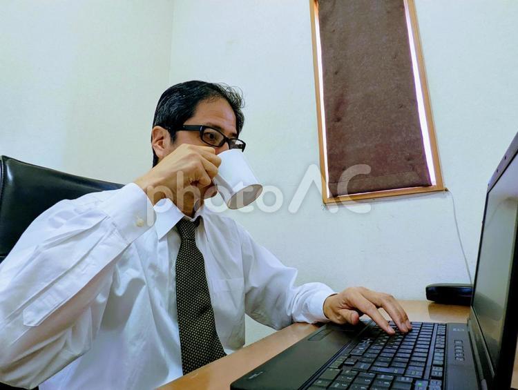 自宅で仕事中にコーヒーを飲む男性 ビジネスマン,仕事,自宅の写真素材