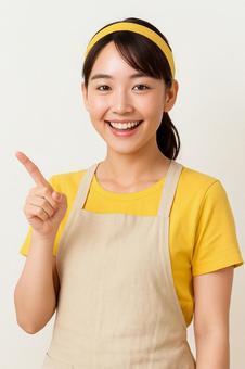 女性が笑顔で指を刺し紹介している風 女性が笑顔で指を刺し紹介している風の写真