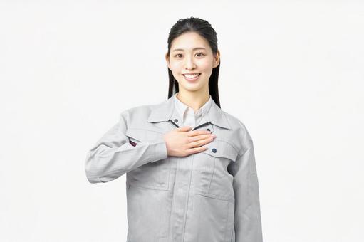 胸に手を置く作業服を着た女性 胸に手を置く作業服を着た女性 作業服,女性,作業員の写真素材