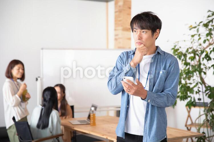 スマホを持つカジュアルな服装のビジネスマン スマホ,アプリ,スマートフォンの写真素材