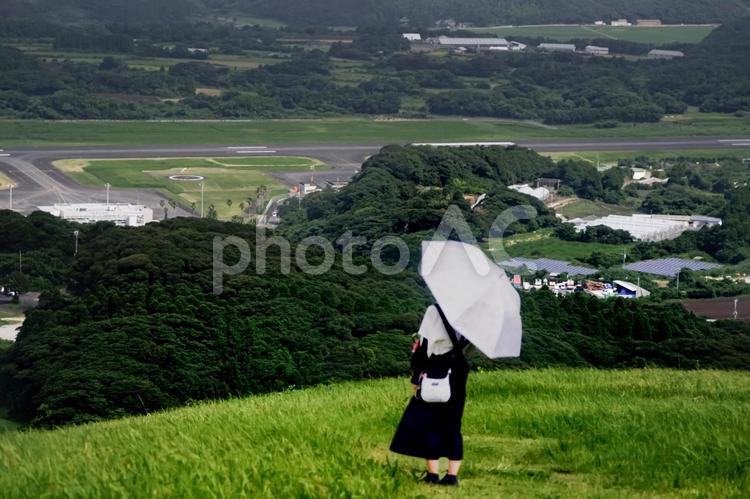 素材＞高台から空港を見下ろす旅行中の女性 女性,人物,日傘の写真素材
