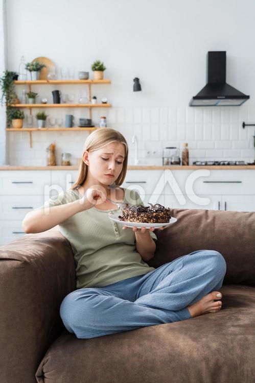 ケーキを持たれながら食べる女性 女性,人物,見るの写真素材