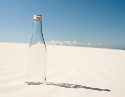 白い砂浜と美しいガラス瓶の写真