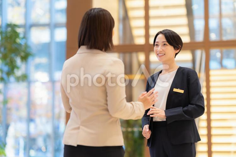お客を案内するホテルマンの女性 フロント,ホテルマン,女性の写真素材