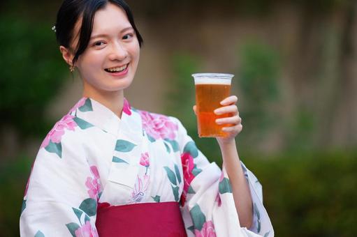 浴衣姿の女性がグラスを持って笑顔 女性,浴衣,ビールの写真素材