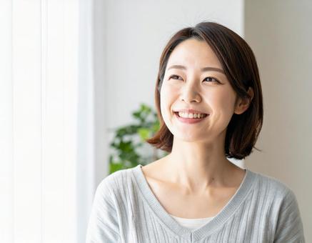 室内で微笑む30代の女性 室内で微笑む30代の女性の写真