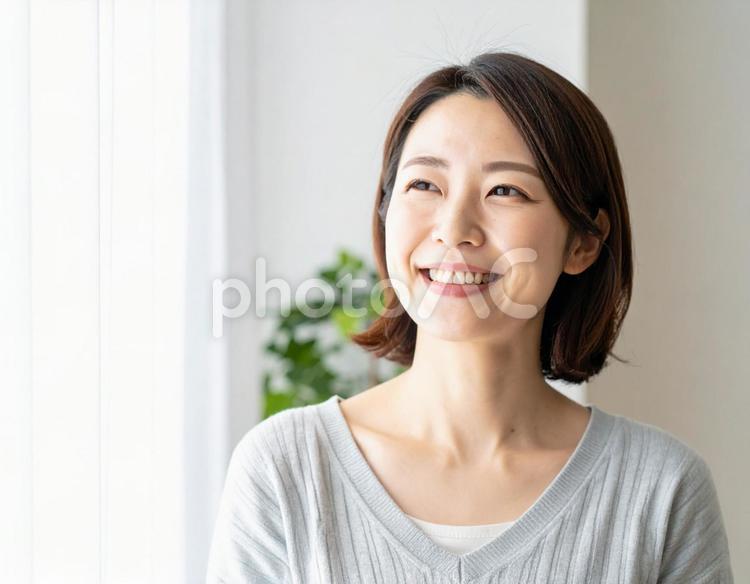 室内で微笑む30代の女性 女性,室内,白背景の写真素材