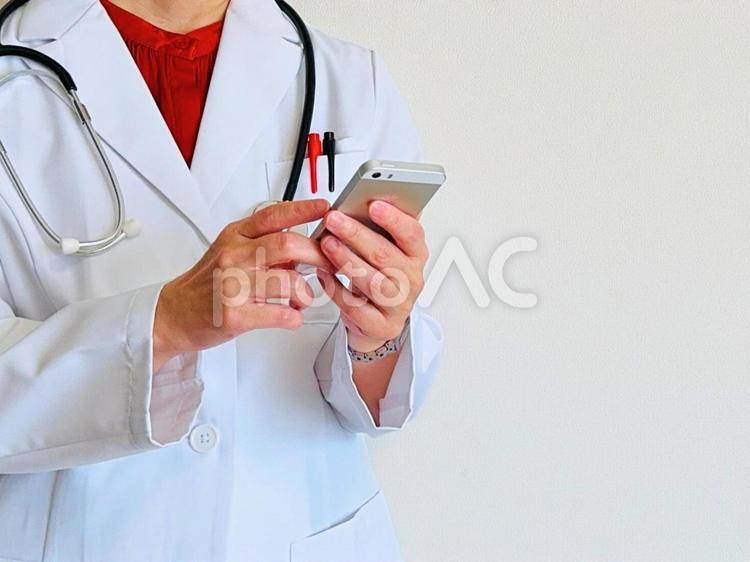スマホを操作する女性医師 スマホ,スマートフォン,医療の写真素材