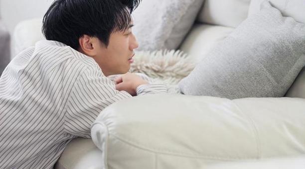 ソファで落ち込むアジア人男性 ソファで落ち込むアジア人男性 男性,落ち込む,ショックの写真素材