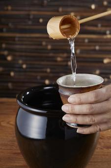 甕に入った焼酎をひしゃくで注ぐ 甕に入った焼酎をひしゃくで注ぐ 焼酎,注ぐ,柄杓の写真素材