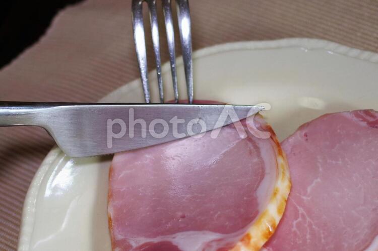厚切りロースハムを切っているところ ロースハム,ハム,食事の写真素材