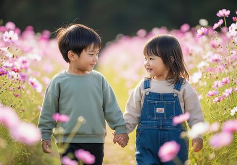 コスモス畑を歩く子供たちの幸せな瞬間の写真