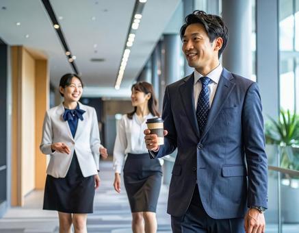 オフィスの廊下で談笑するビジネスパーソンの写真