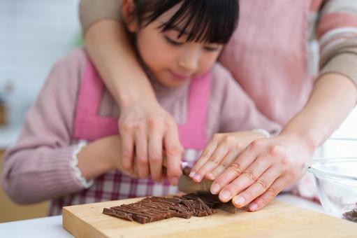 チョコレートを刻む親子の手元 女の子,チョコレート,包丁の写真素材
