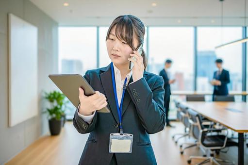タブレットを見て電話するビジネスウーマン タブレットを見て電話するビジネスウーマン 女性,ビジネスウーマン,スーツの写真素材