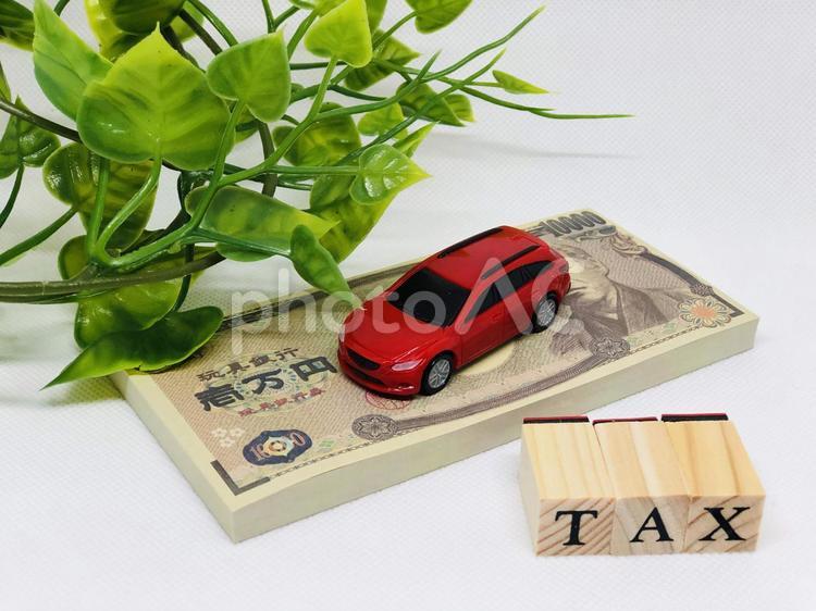 自動車と一万円札とTAXと緑 自動車税,自動車取得税,白背景の写真素材