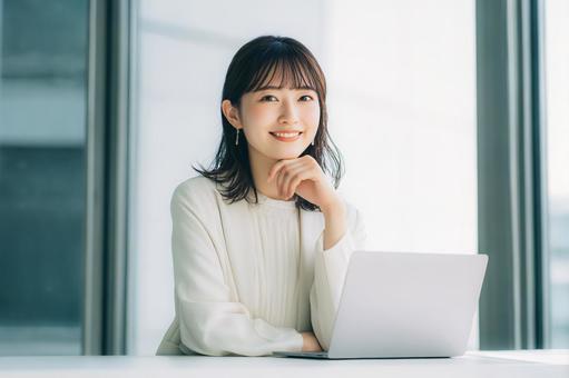ノートパソコンを使用する女性会社員 ノートパソコンを使用する女性会社員の写真