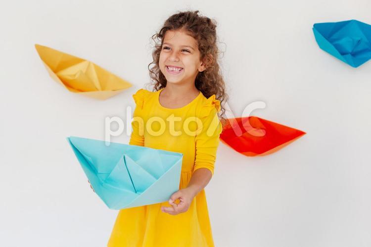 水色の折り紙を持ち笑う女の子 女の子,笑う,折り紙の写真素材