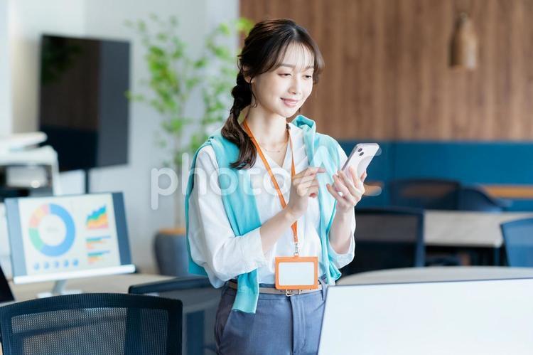 オフィスでスマホを持つビジネスウーマン スマホ,笑顔,ビジネスウーマンの写真素材