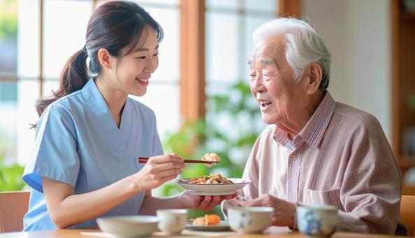 食事介助をする女性介護士と高齢男性 食事介助をする女性介護士と高齢男性の写真