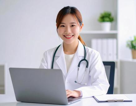 診察室でパソコンを操作する若手の女性医師 診察室でパソコンを操作する若手の女性医師の写真