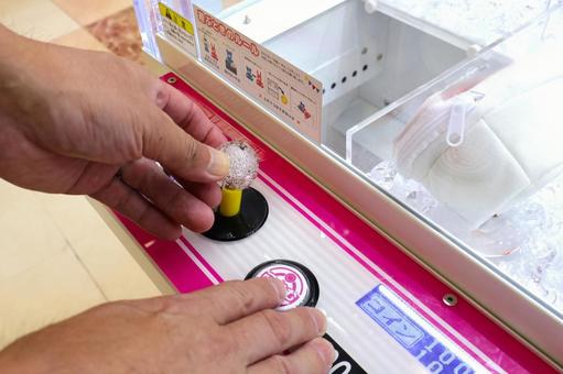 クレーンゲームを操作する男性の手元 クレーンゲームを操作する男性の手元 クレーンゲーム,ゲームセンター,ufoキャッチャーの写真素材