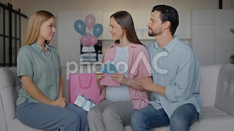 メッセージカードを見終えた夫婦と見つめる女性 女性,男性,人物の写真素材