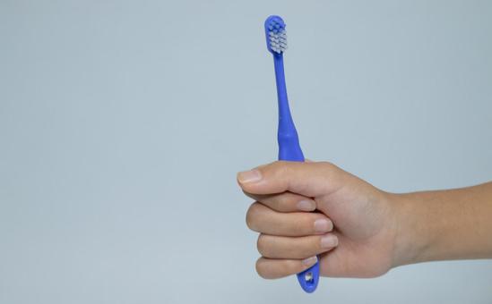 青い歯ブラシを握る手のクローズアップ 歯ブラシ,青,歯磨きの写真素材