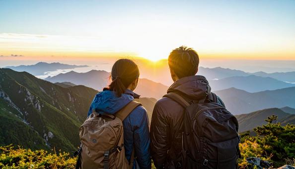 山から朝日を眺める日本人カップル 山から朝日を眺める日本人カップルの写真