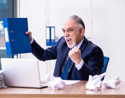 怒りを爆発させる中年ビジネスマン 怒りを爆発させる中年ビジネスマンの写真