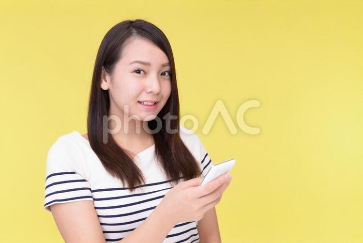 スマートフォンを持つ笑顔の女性 女性,スマートフォン,女の写真素材