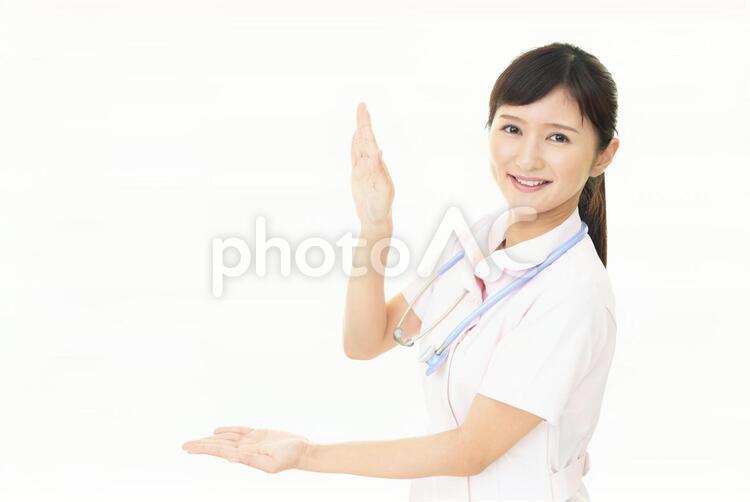掌を見せる笑顔の看護師 女性,女,看護師の写真素材