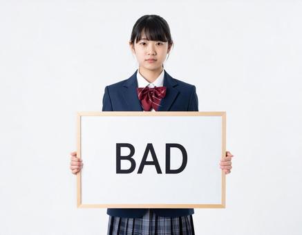 BADと書いたボードをもつ女子生徒 BADと書いたボードをもつ女子生徒の写真