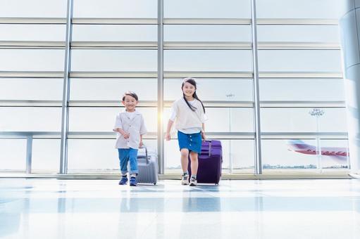 空港でスーツケースをひく子ども 空港でスーツケースをひく子どもの写真