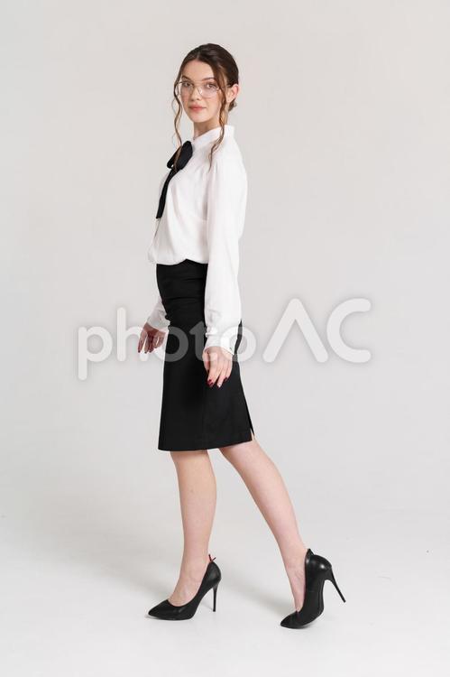カメラ目線で歩くメガネの若い女性 女性,歩く,真顔の写真素材