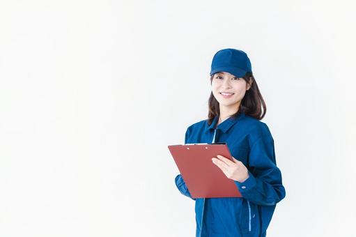 作業服で確認をする女性の現場監督 作業服で確認をする女性の現場監督の写真