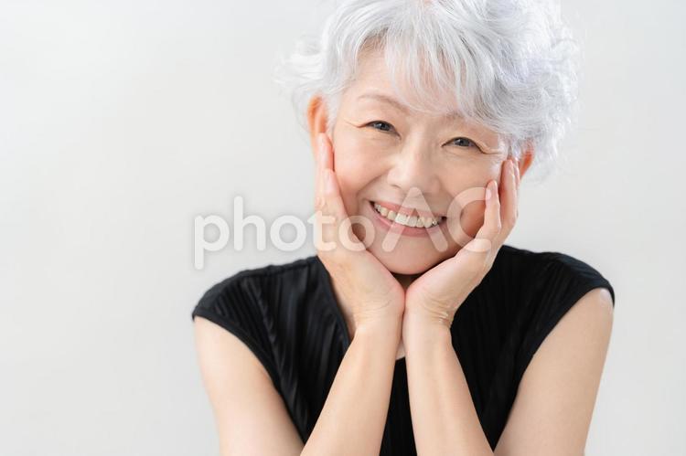 白バックでスキンケアをするシニアの女性 ビューティー,女性,シニアの写真素材