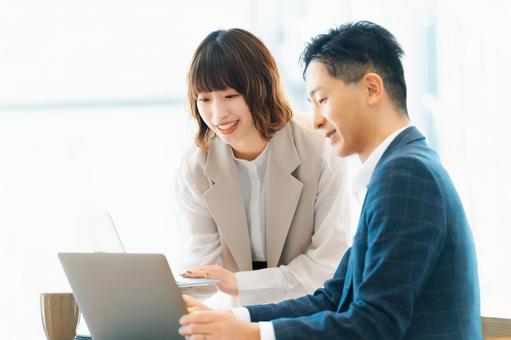 ミーティングをする男女2人のビジネスマン ミーティングをする男女2人のビジネスマンの写真