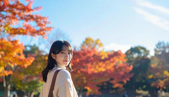 紅葉を背景に笑顔の若い女性 紅葉を背景に笑顔の若い女性の写真