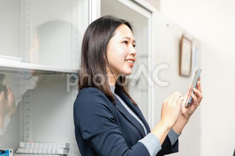 スマホを使うスーツの女性 スマートフォン,携帯電話,電話の写真素材