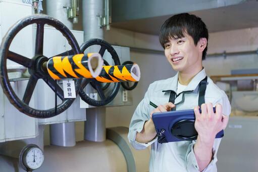 タブレットを持って点検する男性作業員 男性,タブレット,ポンプの写真素材