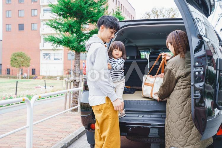 車から大きいバックを取り出す女性 車,自動車,人物の写真素材