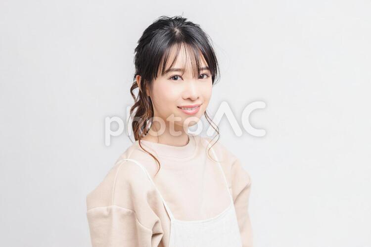 白い背景の前に立ってポーズをとる若い女性 女性,白背景,立つの写真素材