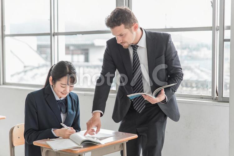 日本人の女子高生を指導する外国人英語講師 授業,高校生,英会話の写真素材
