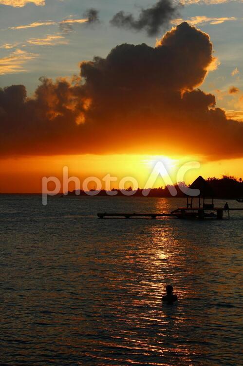 海から夕陽を眺める人 夕陽,夕日,夕暮れの写真素材