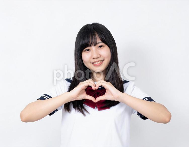手でハートマークを作る女子生徒 女性,ハートマーク,女の子の写真素材
