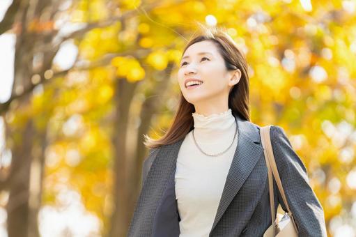 紅葉の街路樹と女性・ビジネスウーマン 女性,秋,紅葉の写真素材