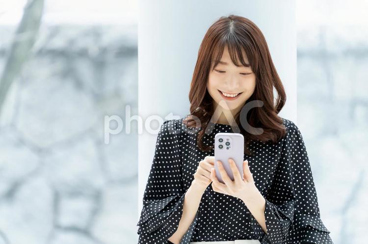 笑顔でスマホを操作をするビジネスウーマン 女性,ビジネス,ビジネスウーマンの写真素材