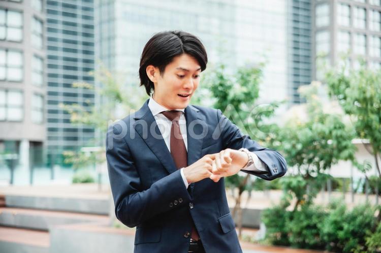 時計を見て焦るビジネスマン（遅刻） 遅刻,忙しい,締め切りの写真素材